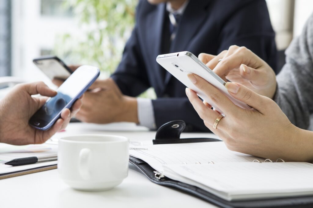 3人のビジネスマンがスマホを持ち操作している