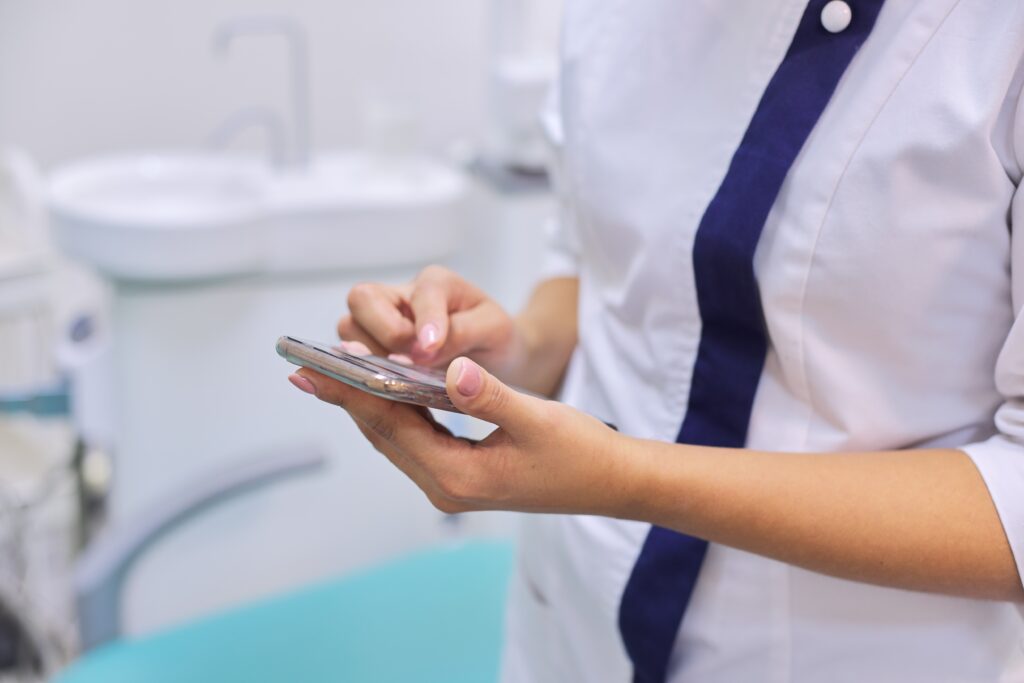 Close up of female doctors hand with mobile phone smartphone