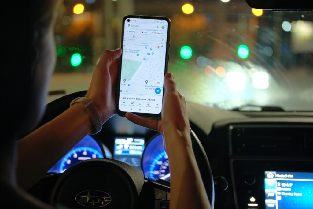 車内でスマートフォンに表示された地図を見ている